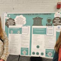 Hannah DeVries and Aubrey Brearley standing in front of their poster presentation